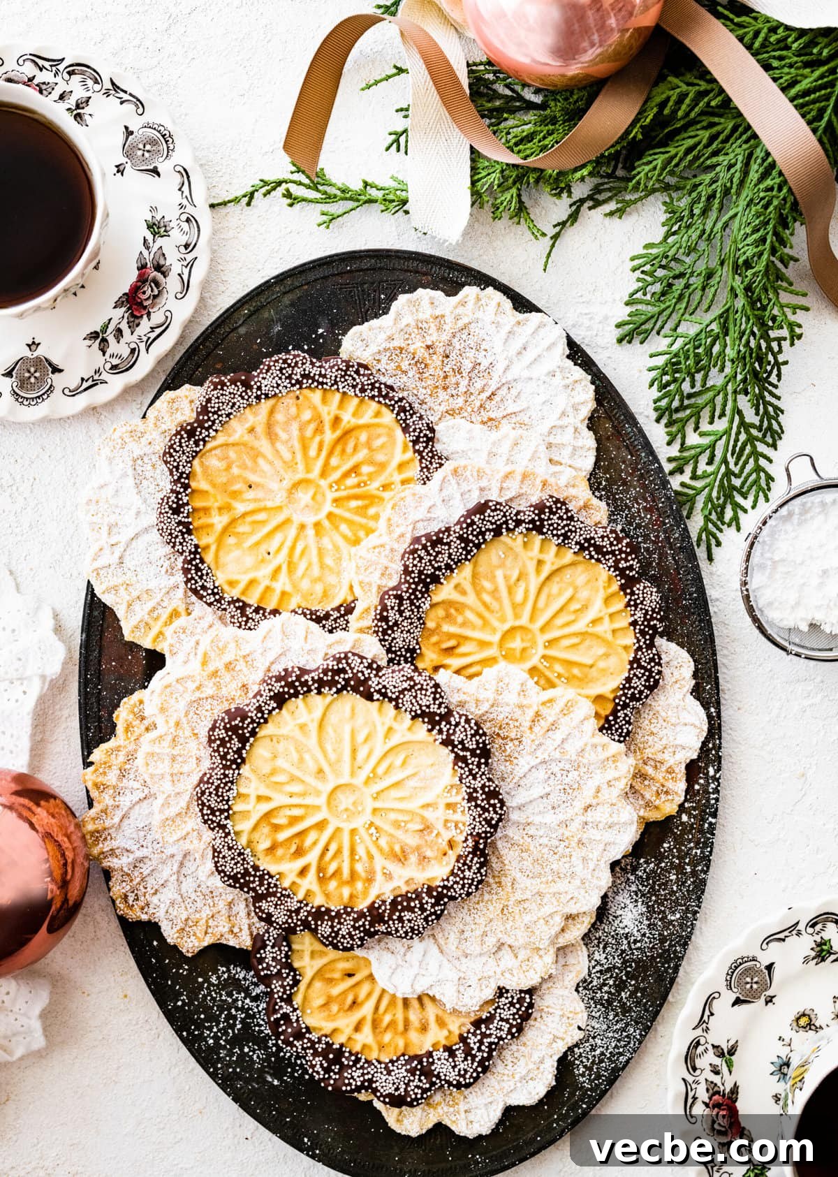 65+ Christmas Dessert Recipes Your Guests Will Love 3 Best pizzelle cookies recipe with dip of chocolate around the edges and tiny white pearl sprinkles.
