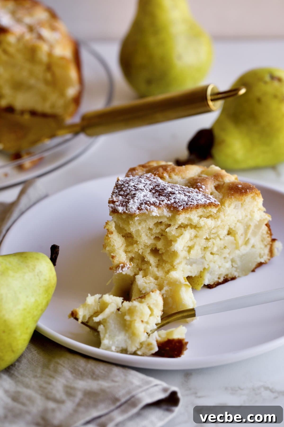 65+ Christmas Dessert Recipes Your Guests Will Love 23 thick slice of Italian pear cake on a plate with a fork.