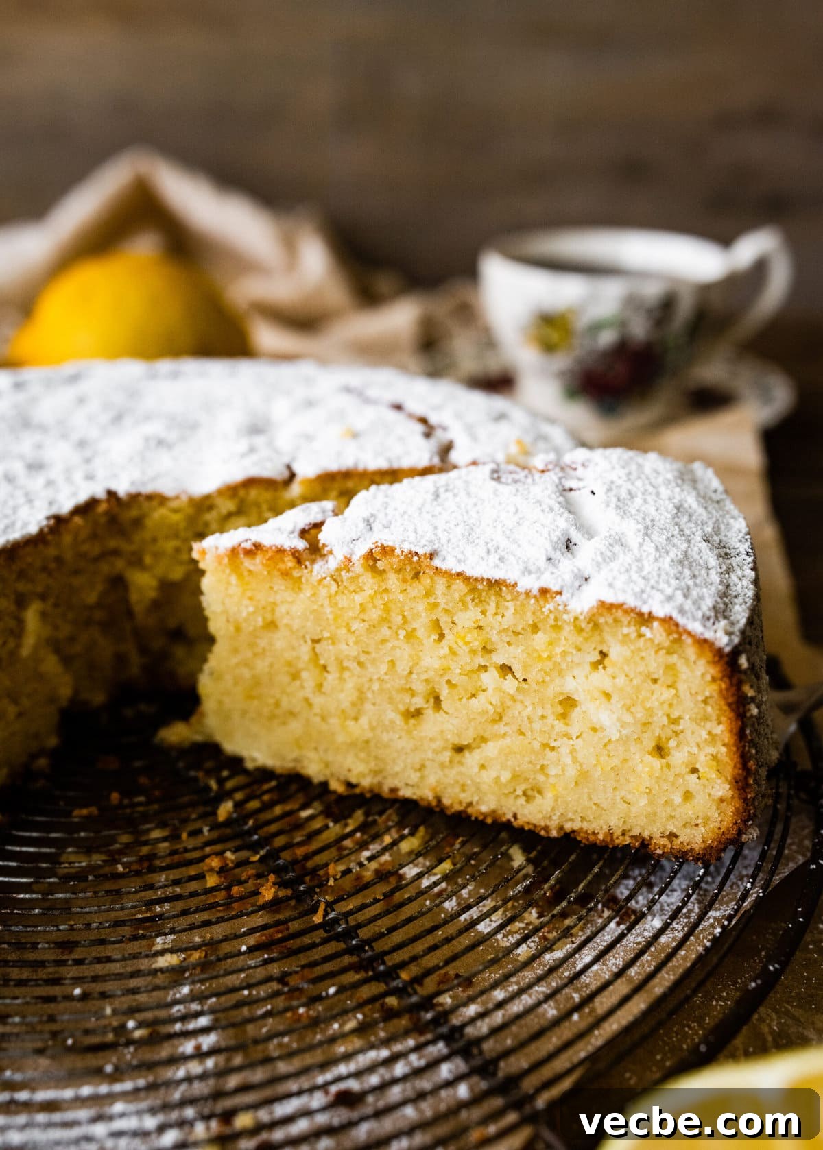 65+ Christmas Dessert Recipes Your Guests Will Love 25 Slice being removed from an olive oil cake with powdered sugar on top.