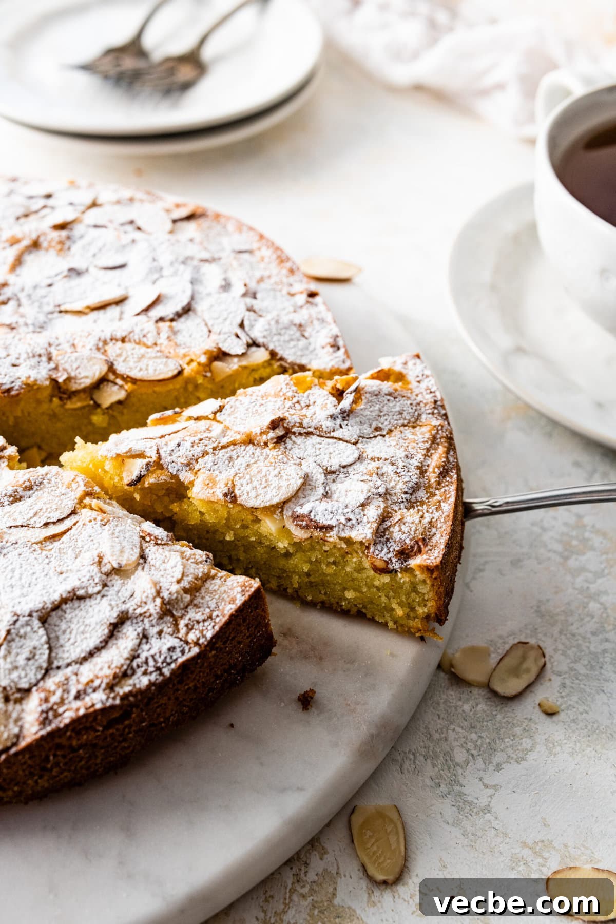 65+ Christmas Dessert Recipes Your Guests Will Love 26 slice taken out of the almond cake with a cake server.