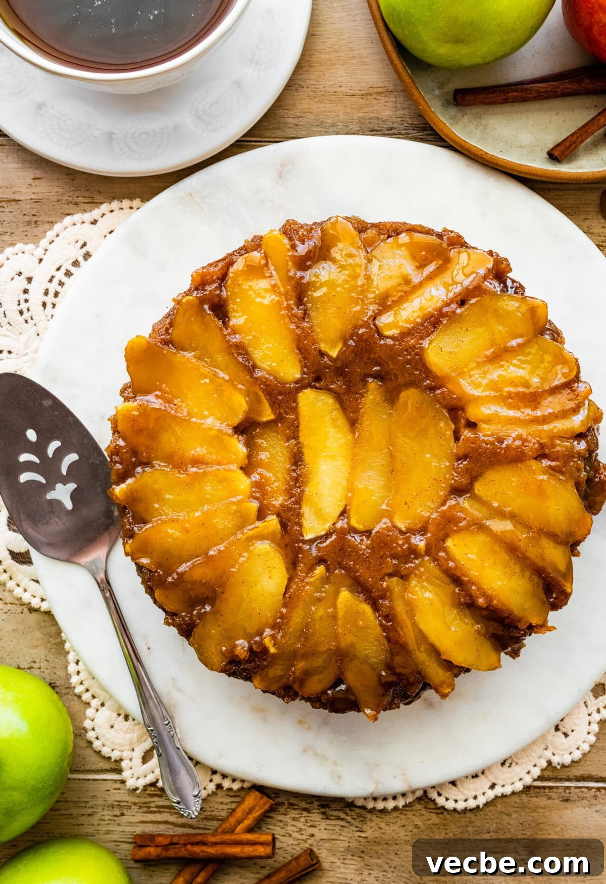 65+ Christmas Dessert Recipes Your Guests Will Love 28 Caramel Apple Upside Down Cake Recipe on a platter. The caramel apple layer is visible on the top.