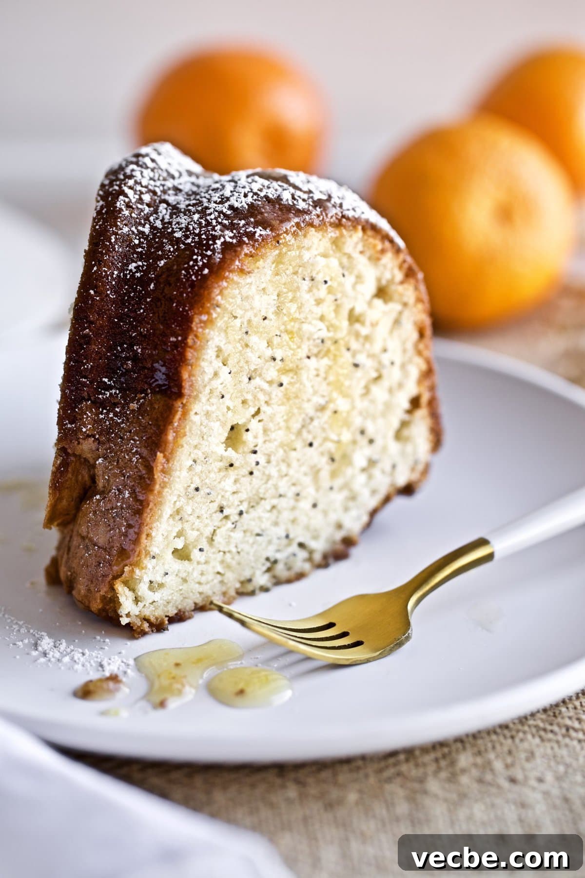 65+ Christmas Dessert Recipes Your Guests Will Love 31 poppyseed almond cake with orange almond glaze slice on a plate