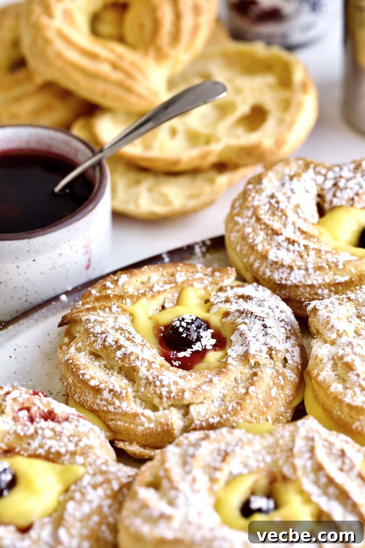 65+ Christmas Dessert Recipes Your Guests Will Love 34 Baked zeppole filled with Italian pastry cream and Italian Amarena cherries on a plate.