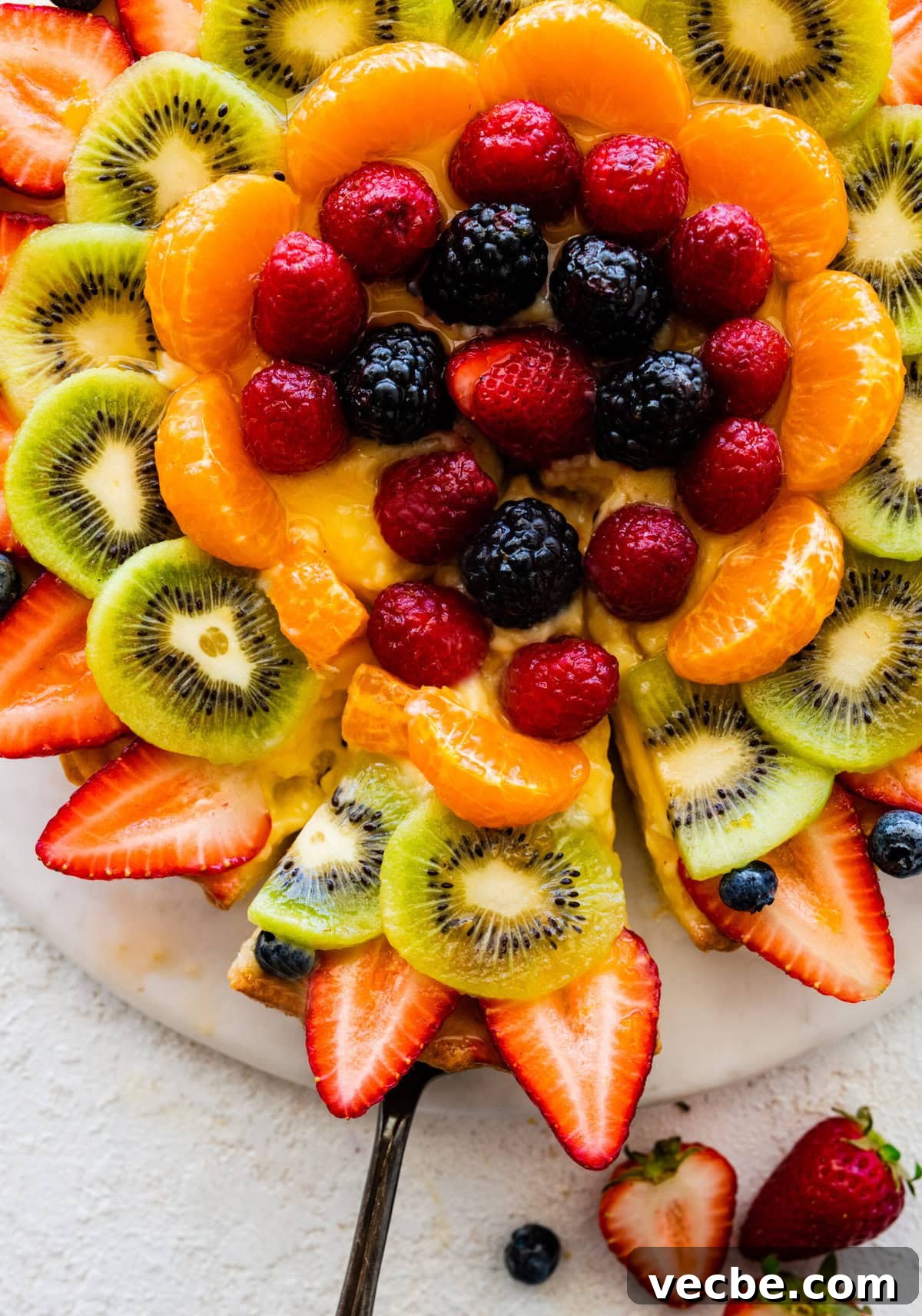 65+ Christmas Dessert Recipes Your Guests Will Love 41 finished crostata di frutta Italian fruit tart on a serving tray ready to serve. Cutting a slice out of the tart.