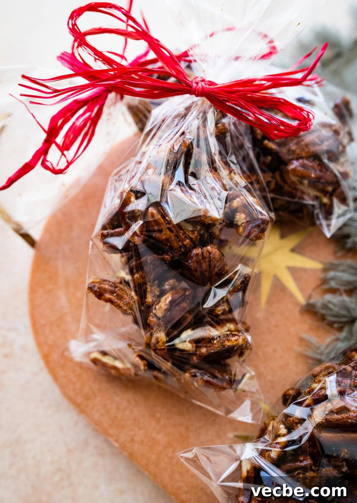 65+ Christmas Dessert Recipes Your Guests Will Love 46 Candied pecan in a clear bag with red ribbon tied around the top to give as a gift.