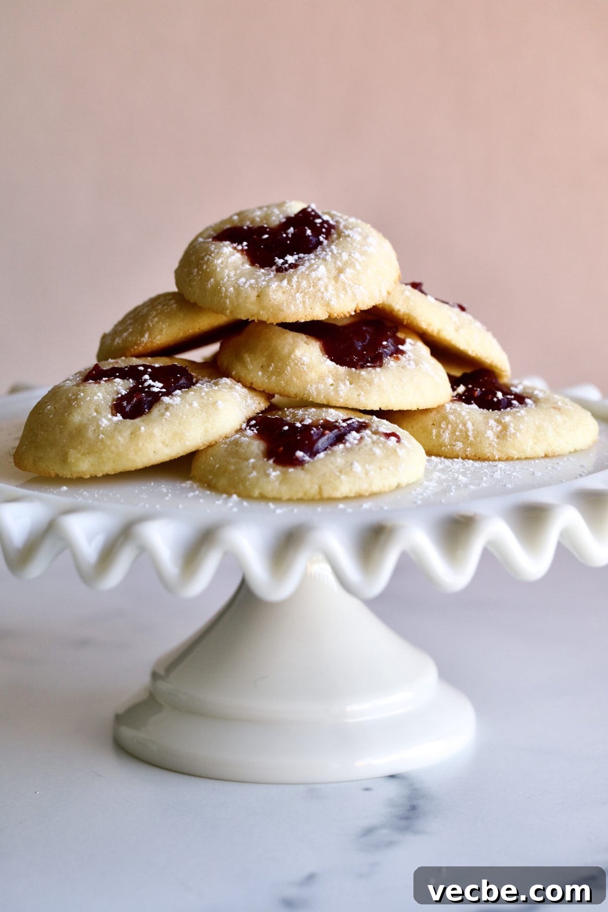 65+ Christmas Dessert Recipes Your Guests Will Love 9 heart shaped cookies on a ruffled cake plate platter.