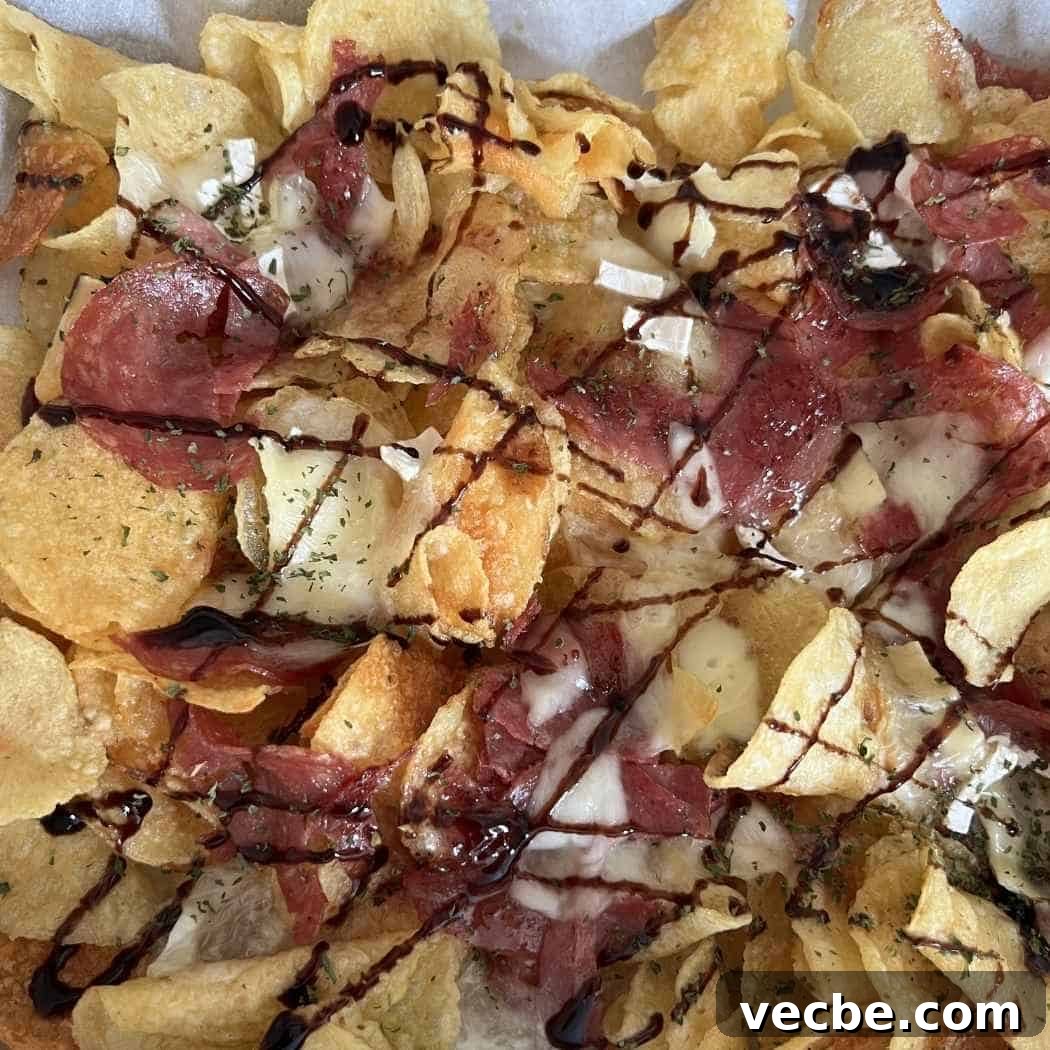 Loaded Charcuterie Nachos Appetizer 5 Finished charcurterie nachos drizzled with balsamic glaze.