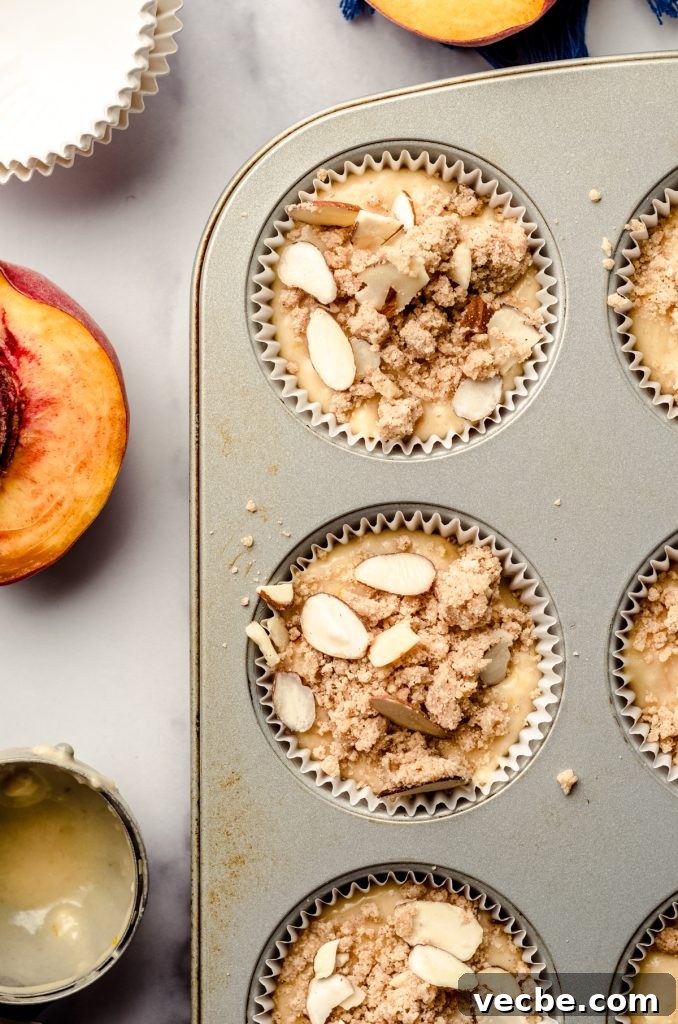 Peach Almond Streusel Muffins with Crumb Topping 11 Peach almond streusel muffin batter in a cupcake pan ready to bake.