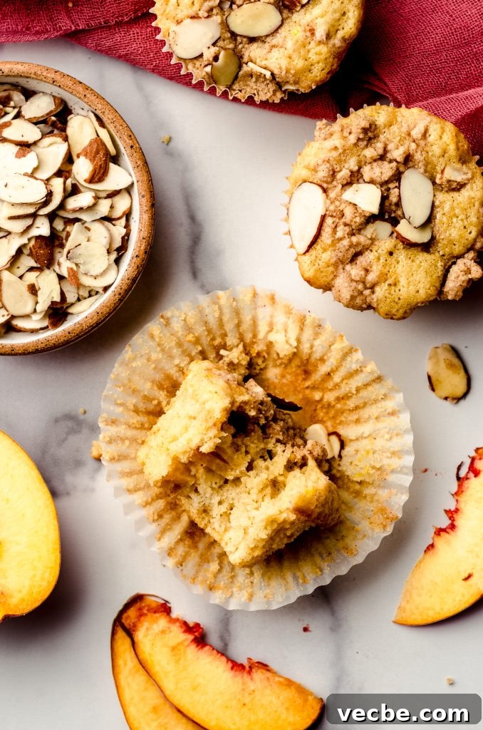 Peach Almond Streusel Muffins with Crumb Topping 12 Aerial photo of a peach almond streusel muffin with a bite taken out of it.