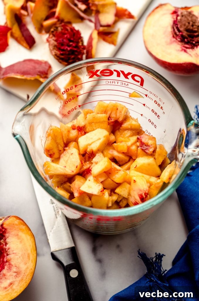 Peach Almond Streusel Muffins with Crumb Topping 15 A measuring cup full of chopped peaches.