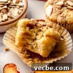 Peach Almond Streusel Muffins with Crumb Topping 16 A photo of a peach almond streusel muffin with a bite taken out of it.