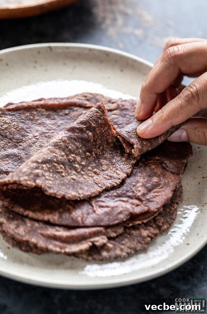 Ragi Roti Recipe: Traditional Finger Millet Flatbread 6 a hand breaking off a portion of the ragi roti