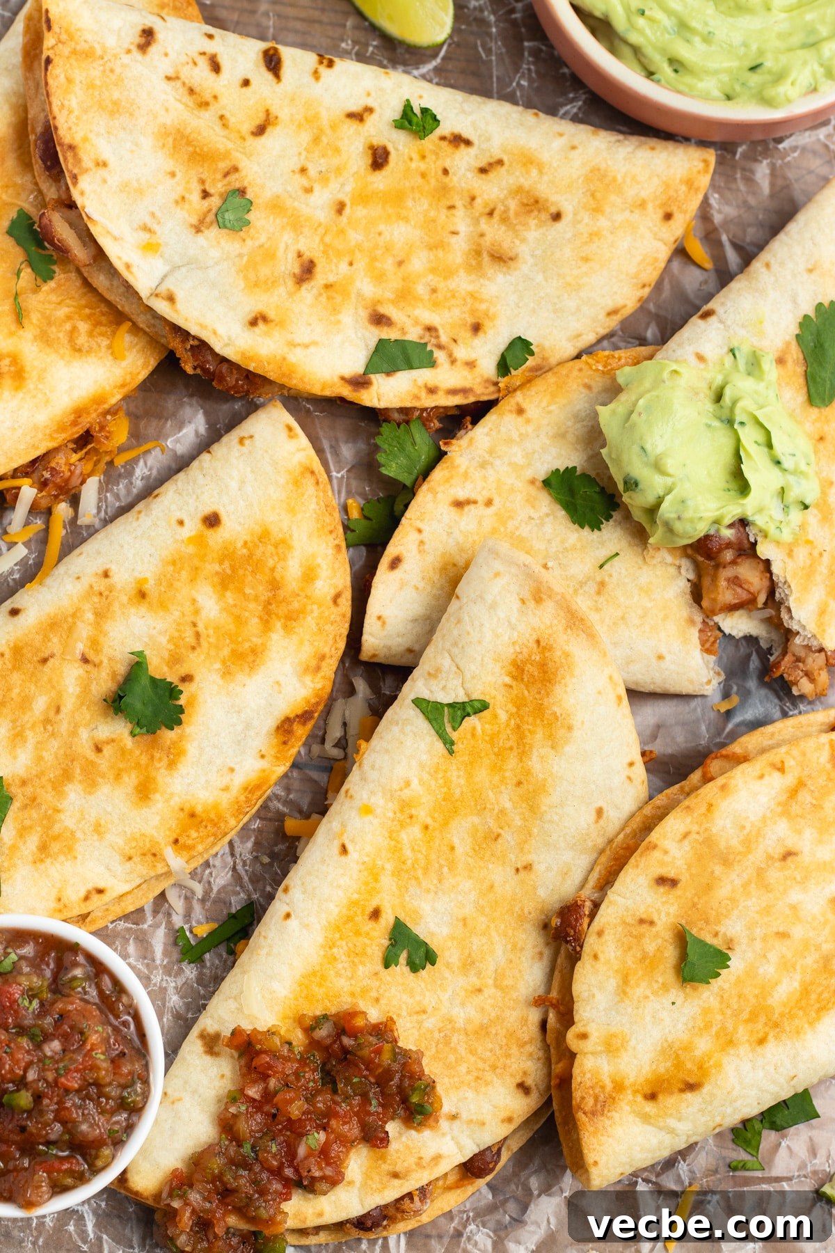 Crispy Baked Bean and Cheese Tacos with Avocado Crema 2 This is a picture of multiple baked crispy bean and cheese tacos.