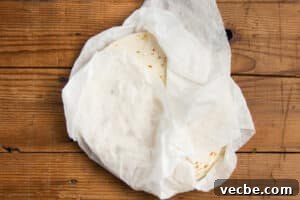 Crispy Baked Bean and Cheese Tacos with Avocado Crema 16 This is a picture of tortillas wrapped in damp paper towels.