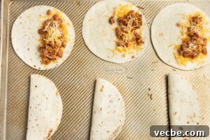 Crispy Baked Bean and Cheese Tacos with Avocado Crema 17 This is a picture of the tortillas being filled with bean and cheese.
