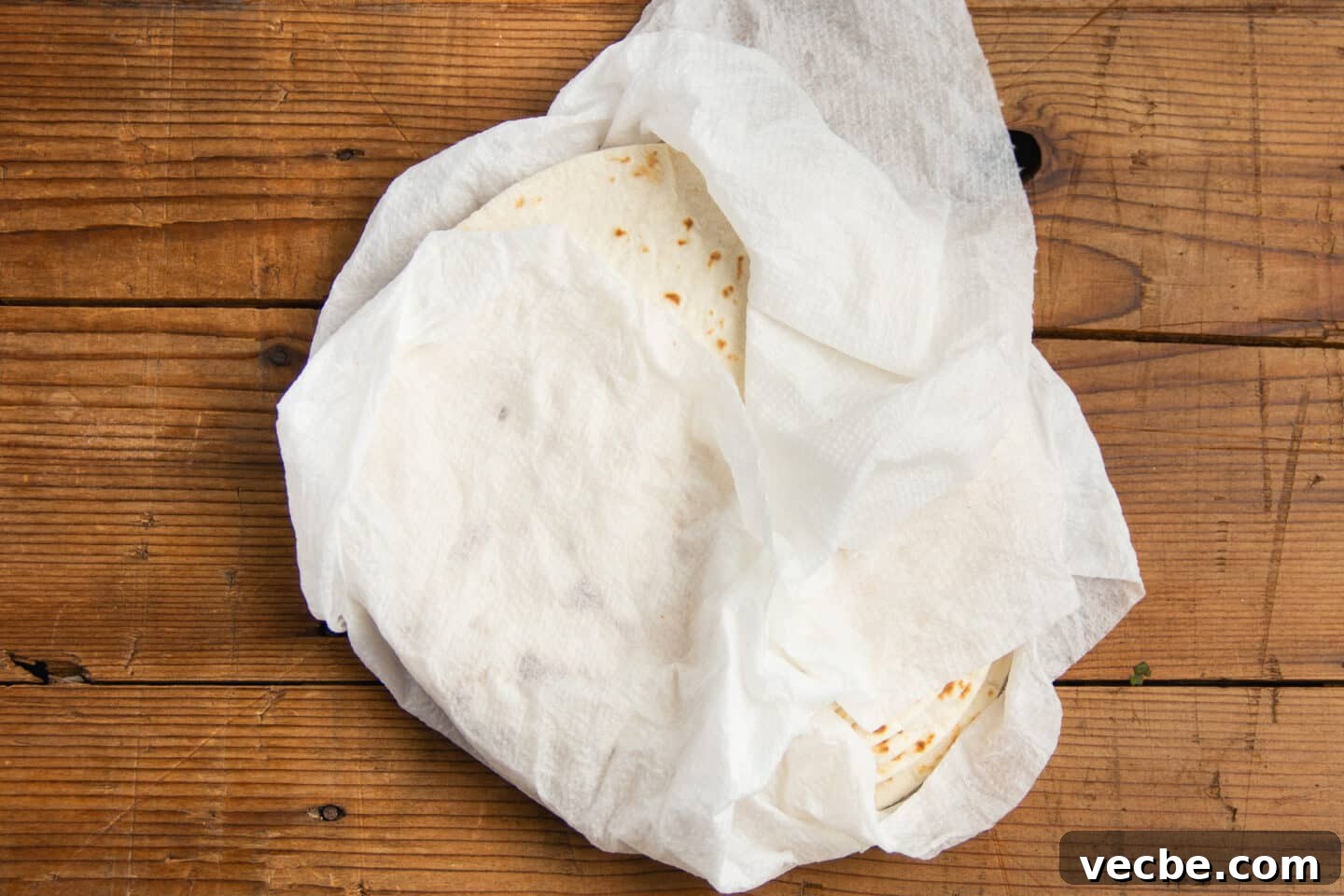 Crispy Baked Bean and Cheese Tacos with Avocado Crema 9 This is a picture of tortillas wrapped in damp paper towels.