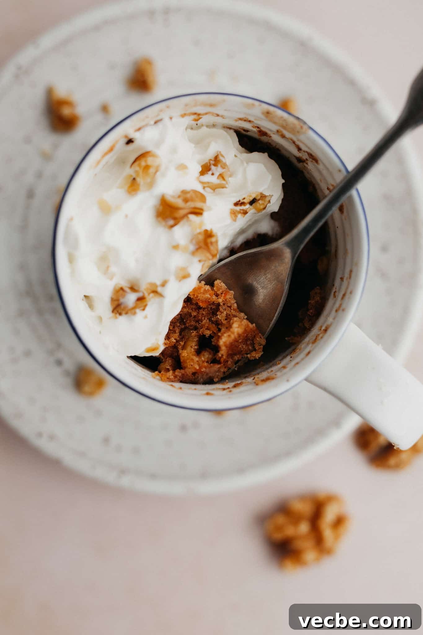 Carrot Mug Cake Recipe 5 An overhead shot of a carrot mug cake topped with whipped cream.