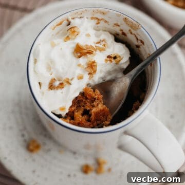 Carrot Mug Cake Recipe 10 An overhead shot of a carrot mug cake topped with whipped cream.