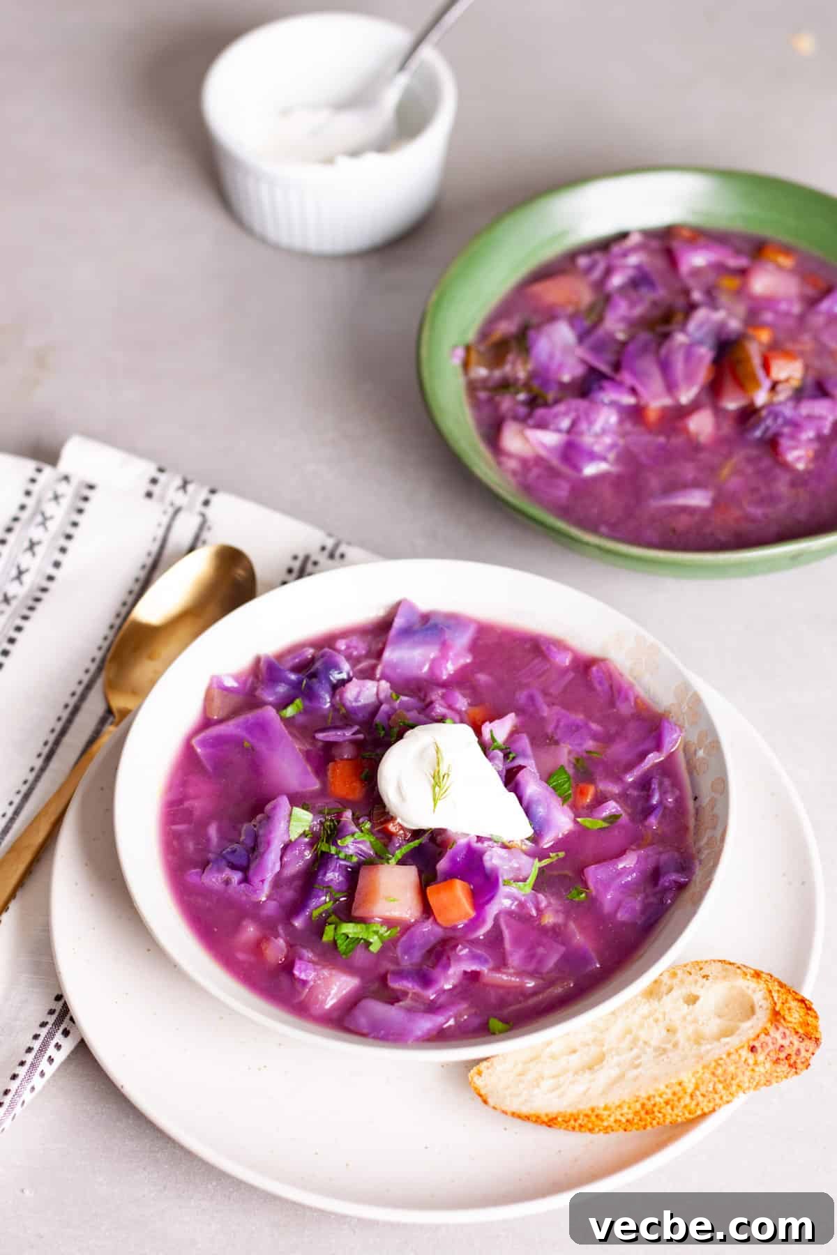 Comforting Red Cabbage Soup Recipe 11 A couple servings of hearty red cabbage soup, one topped with sour cream and fresh herbs.