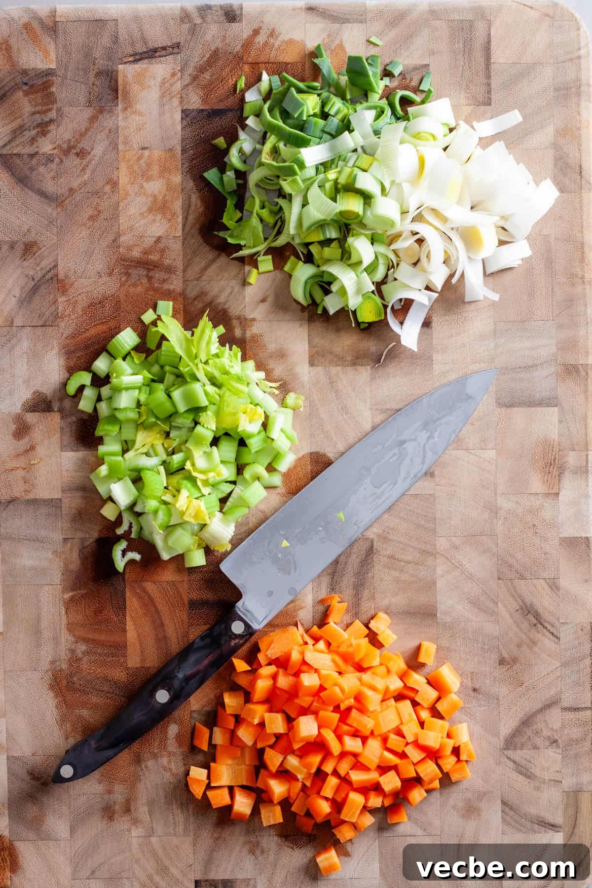 Comforting Red Cabbage Soup Recipe 4 Celery, carrots and a leek chopped on a butcherblock cutting board.
