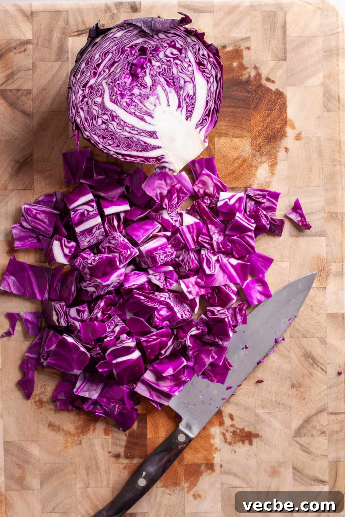 Comforting Red Cabbage Soup Recipe 5 Red cabbage roughly chopped on a butcherblock cutting board.