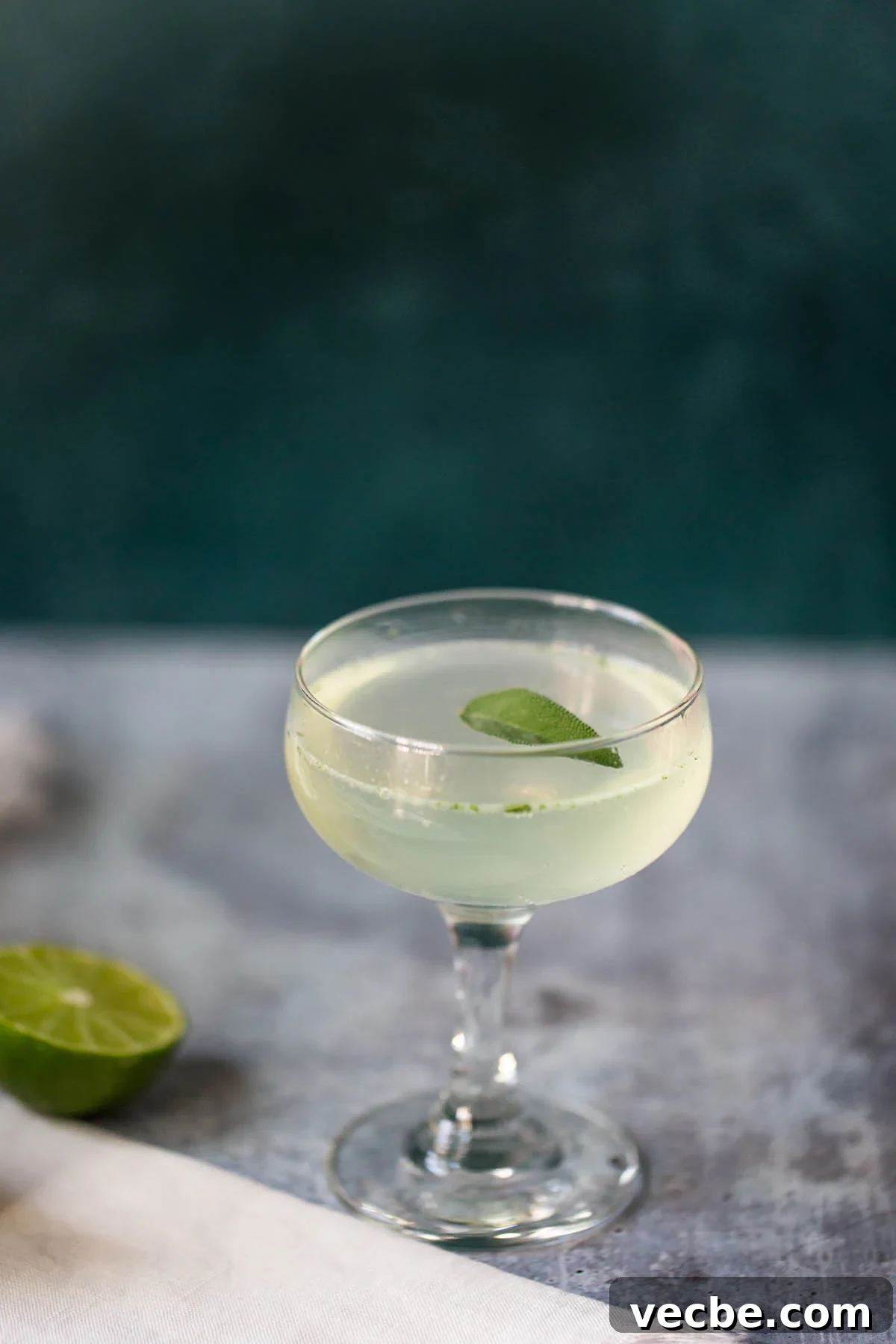 Holiday Mocktail Recipes for Festive Gatherings 4 sage lime mocktail topped with a sage leaf in a coupe glass