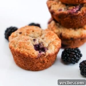 Banana Blackberry Oatmeal Muffins Recipe 10 One Blackberry Banana Oatmeal Muffin in the center with a few blackberries and stacked muffins in the background.