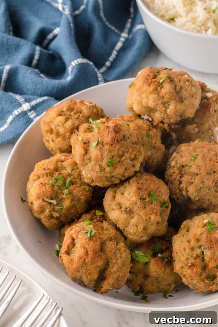 Baked Turkey Meatballs in Marinara Sauce 2 Turkey Meatballs on white serving board.
