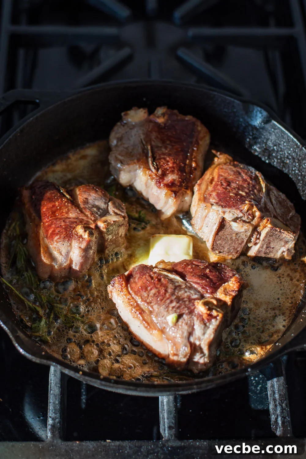 Pan-Seared Lamb Loin Chops with Cognac Butter Recipe 3 Lamb searing in a cast iron skillet with cognac and butter.