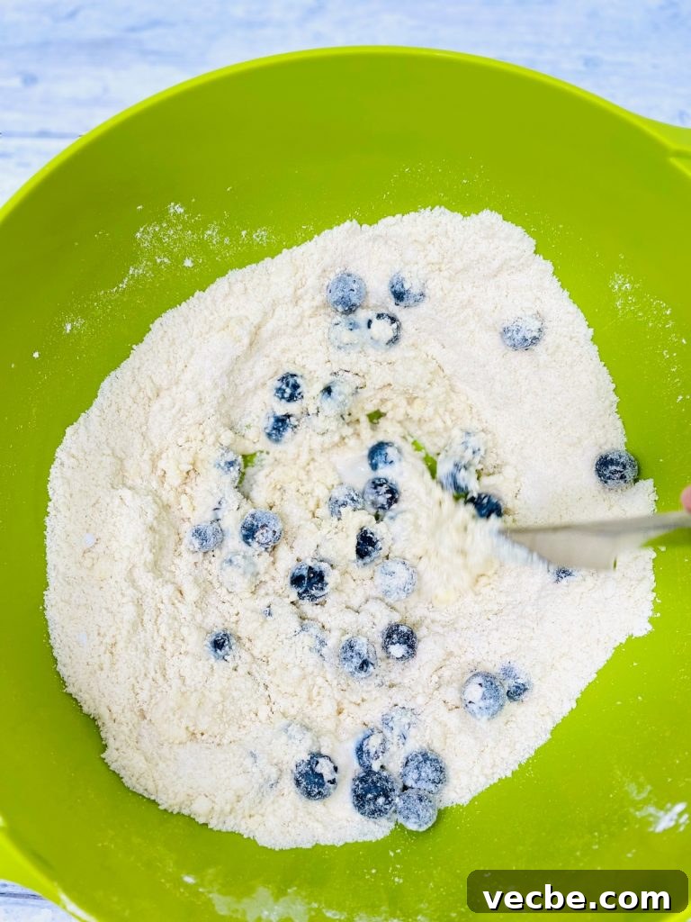 Buttery Blueberry Scones Recipe for Flaky, Tender Results 6 blueberry scone dough being mixed with a knife