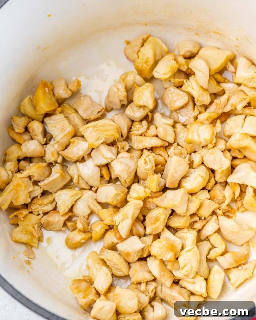 Creamy Chicken Gnocchi Soup Recipe 5 Chicken pieces cooking in a large pot.