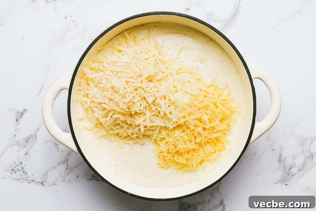 Creamy Chicken Cordon Bleu Casserole Recipe 4 Large pan with cream sauce and shredded cheese.