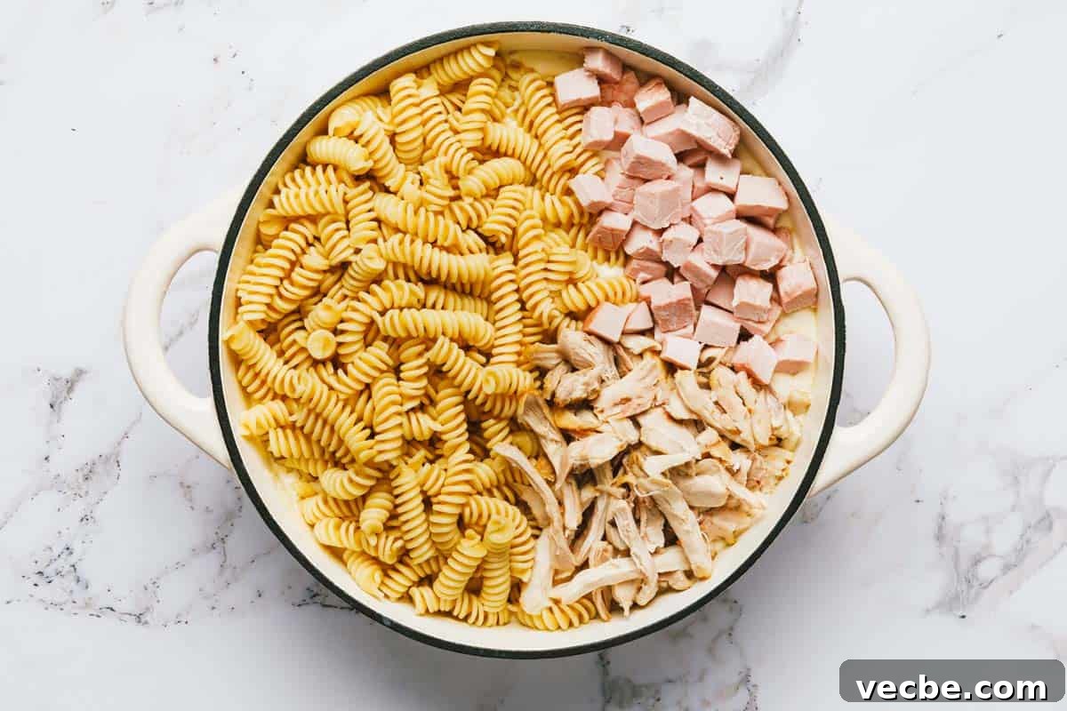 Creamy Chicken Cordon Bleu Casserole Recipe 5 Large pan with pasta, ham, chicken, and cream sauce.
