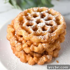 Crispy Rosette Cookies Recipe 11 Stacked rosette cookies on a white plate with holly