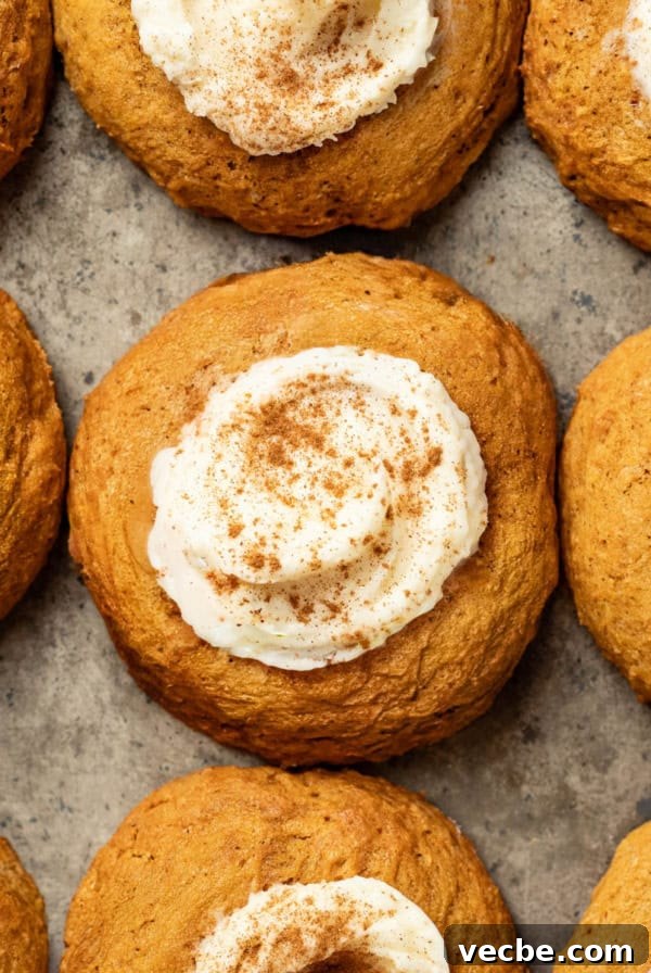 Crispy Rosette Cookies Recipe 8 A baking sheet with pumpkin cookies topped with cream cheese frosting and cinnamon.