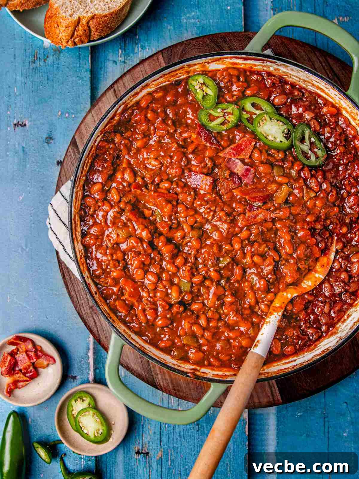 One-Pot Baked Beans with Ground Beef Recipe 8 One pot beans casserole in a skillet garnished with jalapenos and bacon.