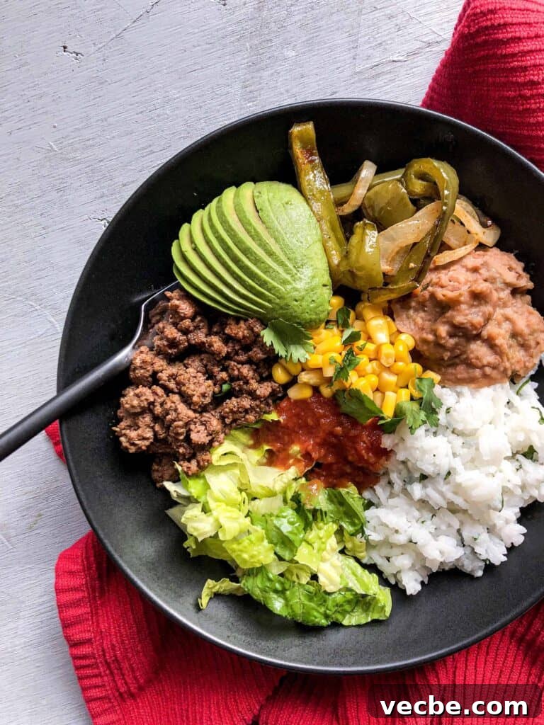 Gluten-Free Burrito Bowls with Rice and Beans 2 A burrito bowl with lots of veggies next to a red towel