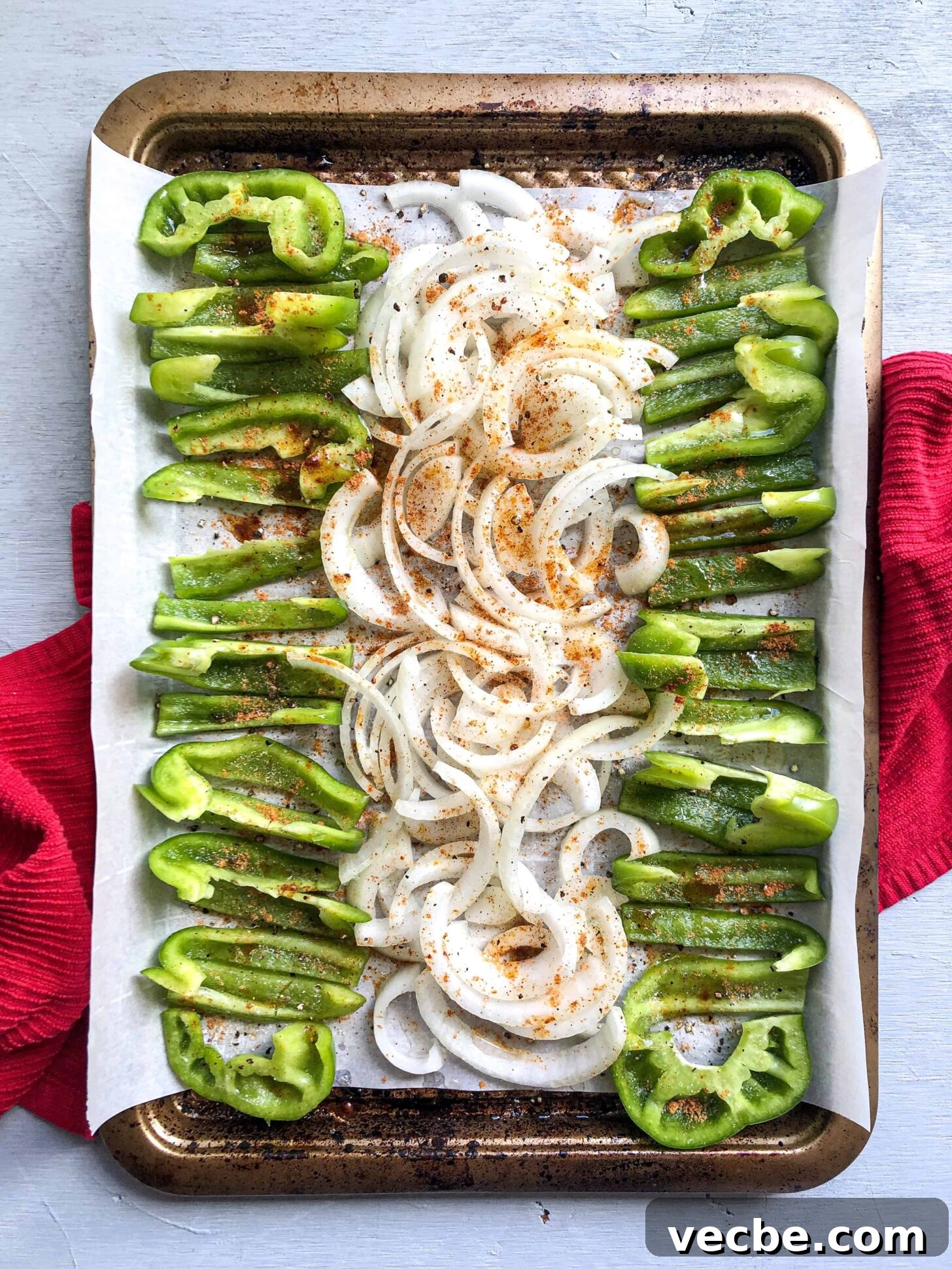 Gluten-Free Burrito Bowls with Rice and Beans 3 A sheet pan full of onion and green pepper with seasonings