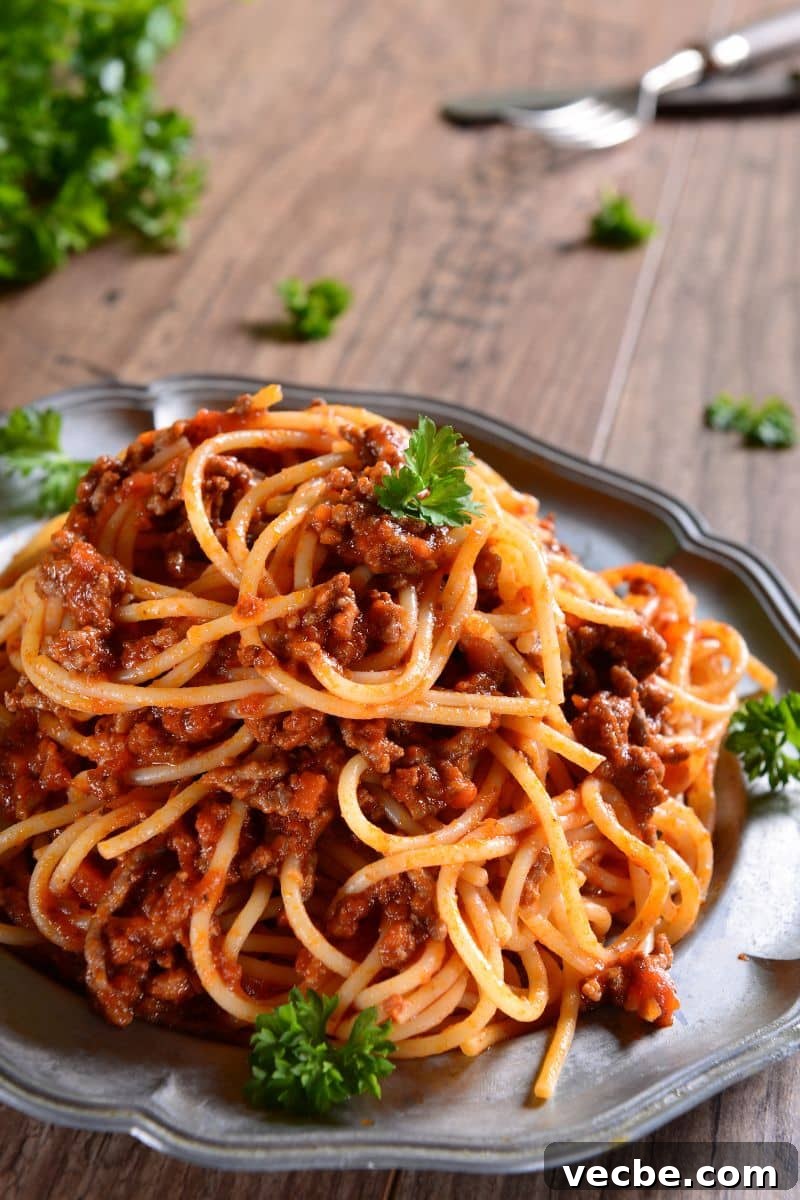 Instant Pot Spaghetti Bolognese Recipe 2 a plate of spaghetti garnished with parsley.