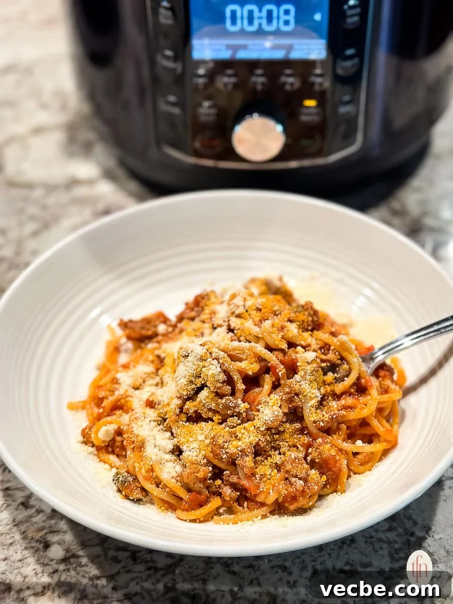 Instant Pot Spaghetti Bolognese Recipe 6 a bowl of spaghetti with an Instant Pot in the background.