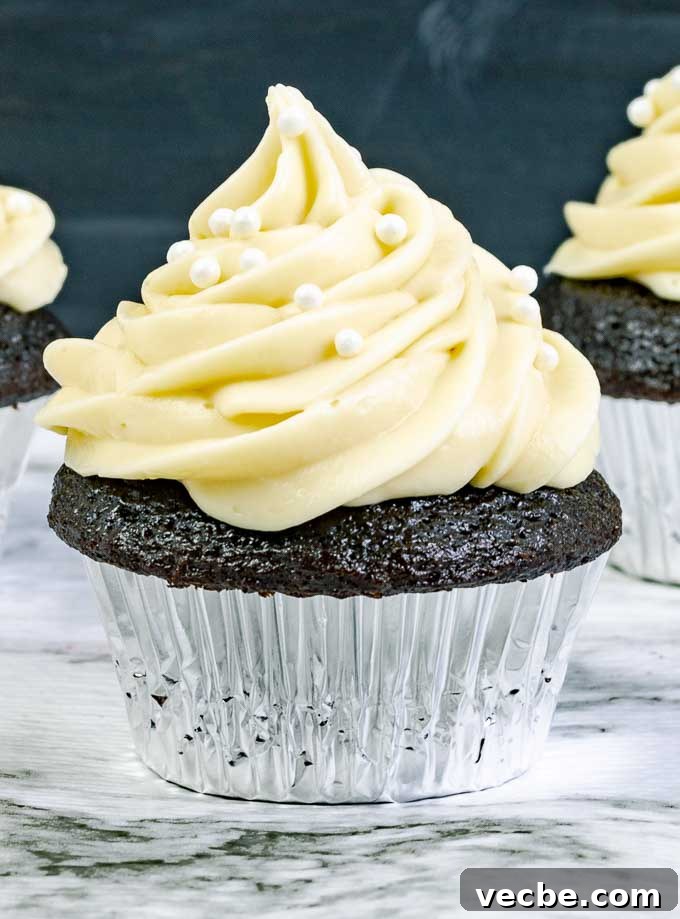 Guinness Dark Chocolate Cupcakes with Irish Cream Frosting 5 close up of a Guinness Dark Chocolate Cupcake with Irish Cream Cream Cheese Frosting in a silver wrapper