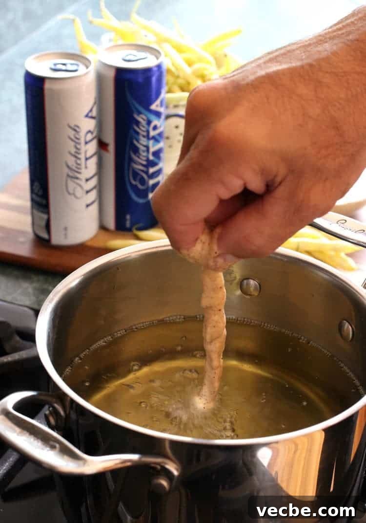 Beer battered green beans frying until crisp and golden brown. Beer Battered Green Beans deep fry