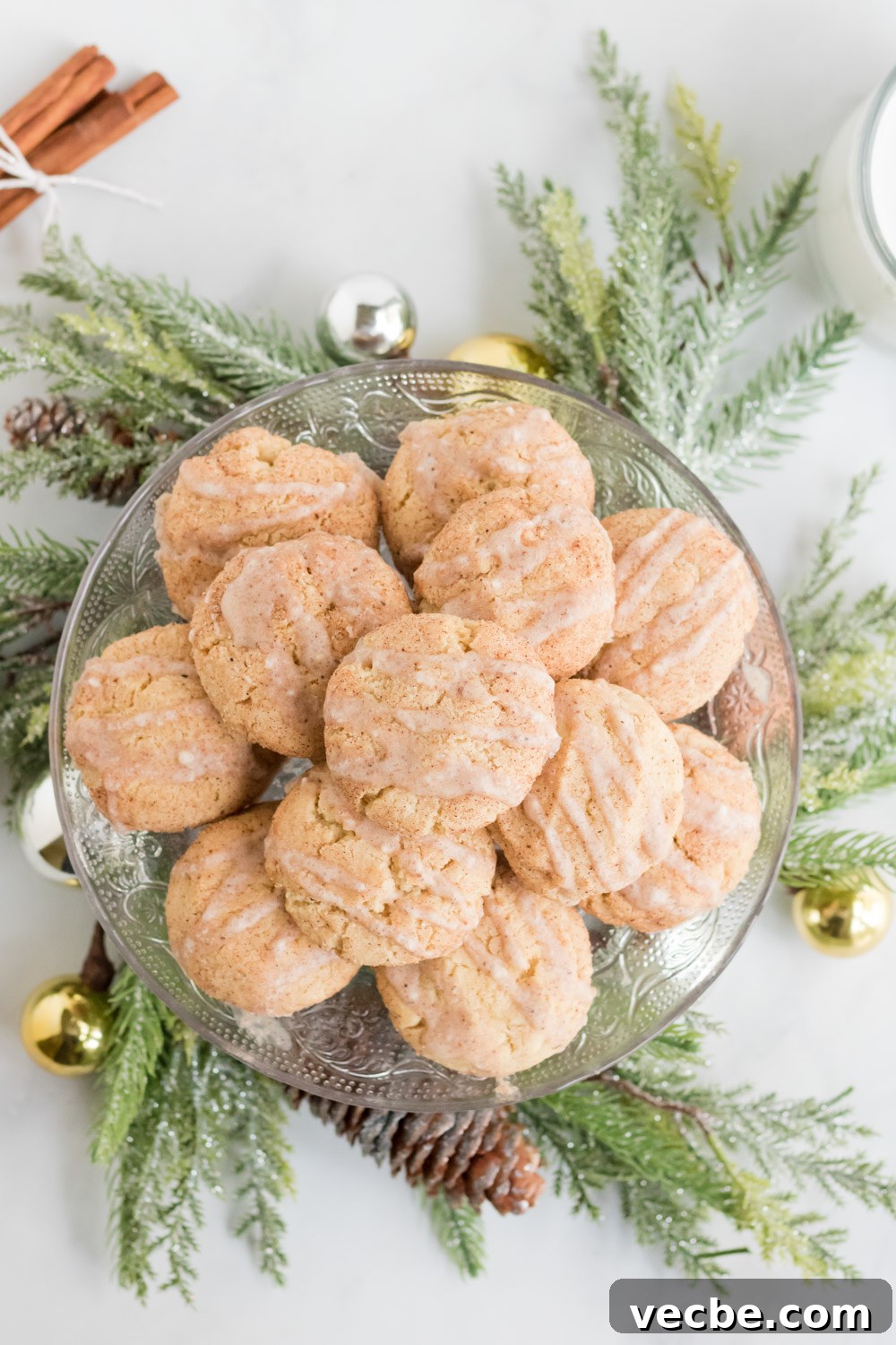 Soft Eggnog Cookies with Warm Holiday Spices 2 Eggnog cookies on a platter with a Christmas wreath around the base.