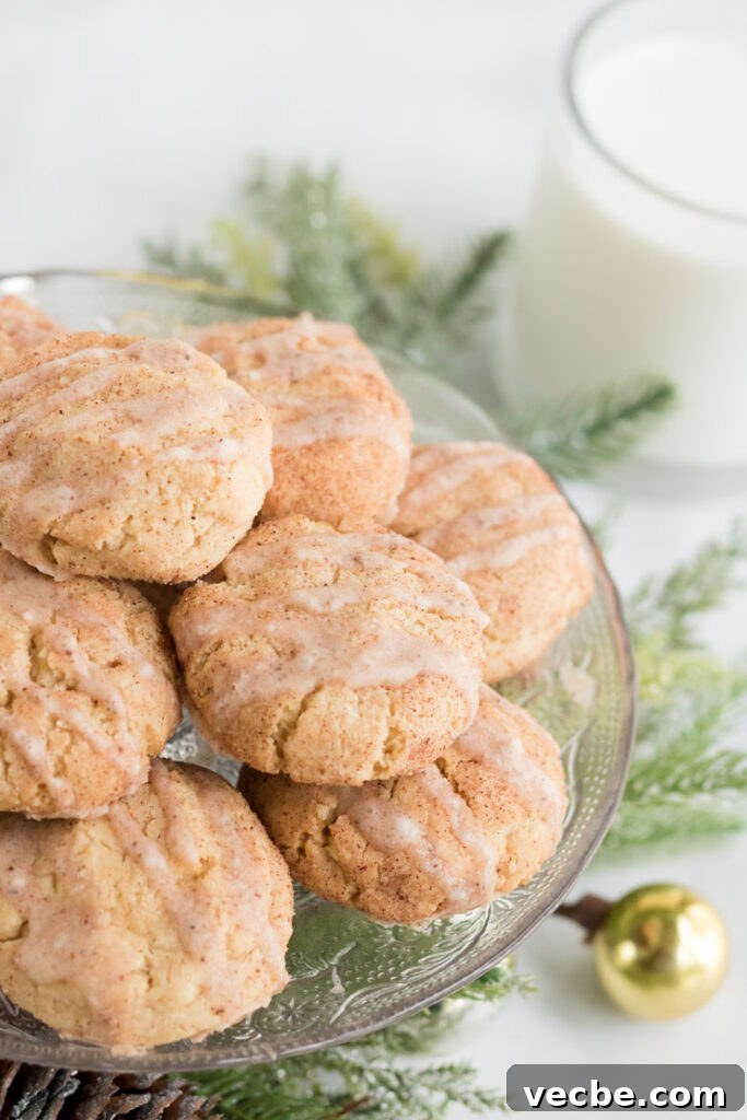Soft Eggnog Cookies with Warm Holiday Spices 13 Eggnog cookies on a platter with a glass of milk behind them.