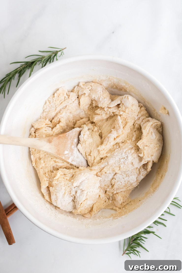 Soft Eggnog Cookies with Warm Holiday Spices 8 Eggnog cookie dough in a bowl with a wooden spoon.