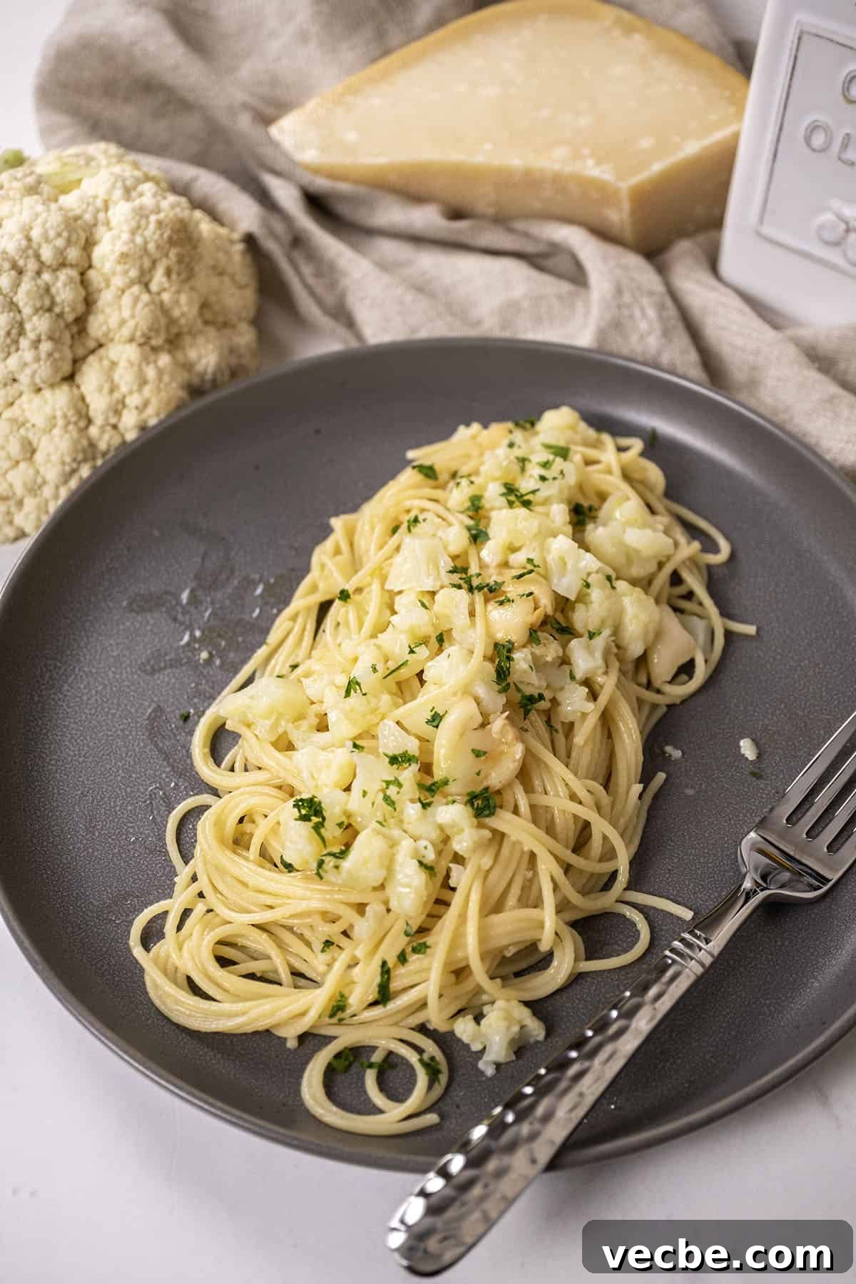 Roasted Cauliflower Pasta with Garlic and Parmesan 2 spaghetti with cauliflower plated on a dish garnished with parsley.