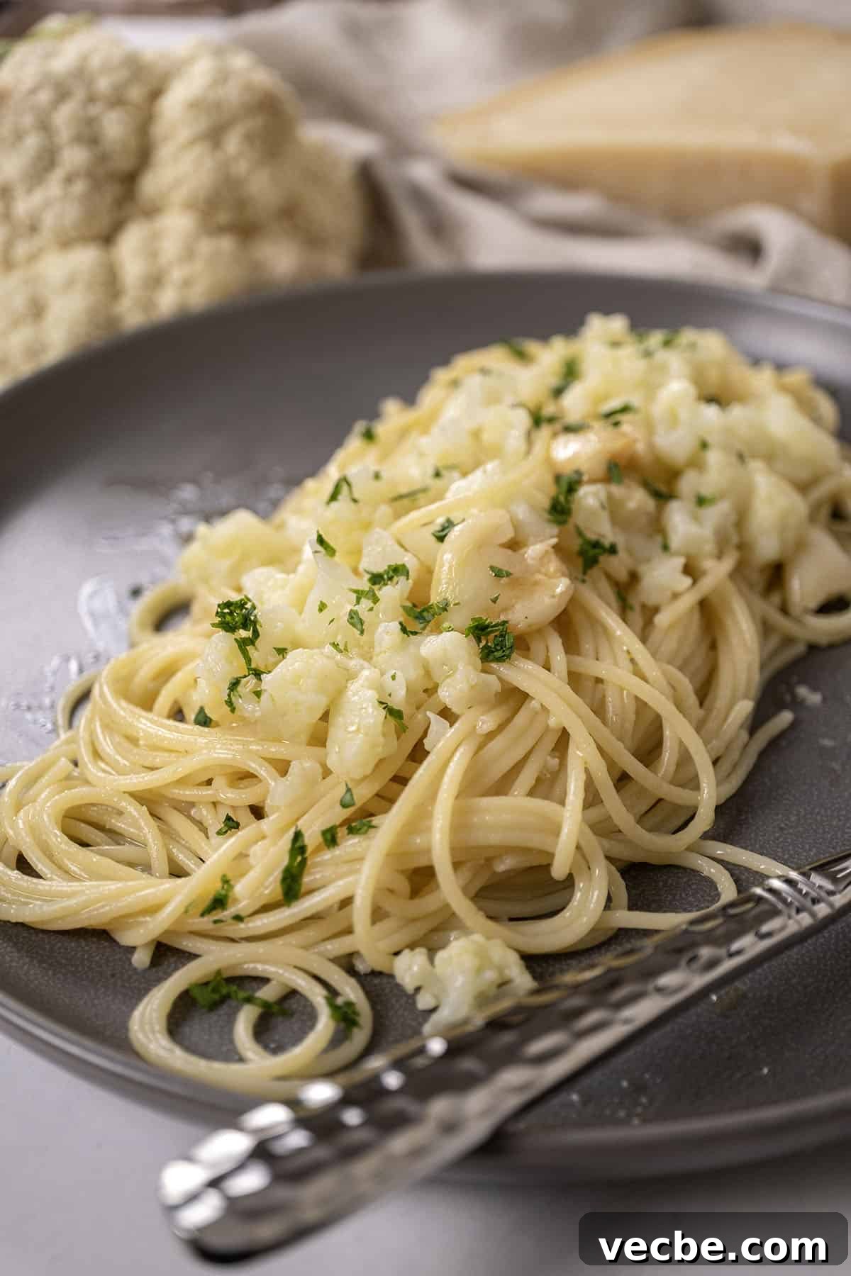 Roasted Cauliflower Pasta with Garlic and Parmesan 8 spaghetti with cauliflower plated on a dish garnished with parsley.