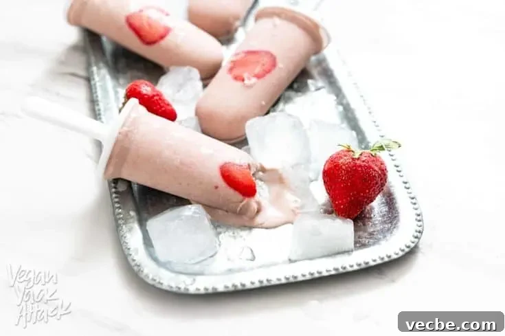 Strawberry Oat Milk Popsicles on a metal platter with ice cubes