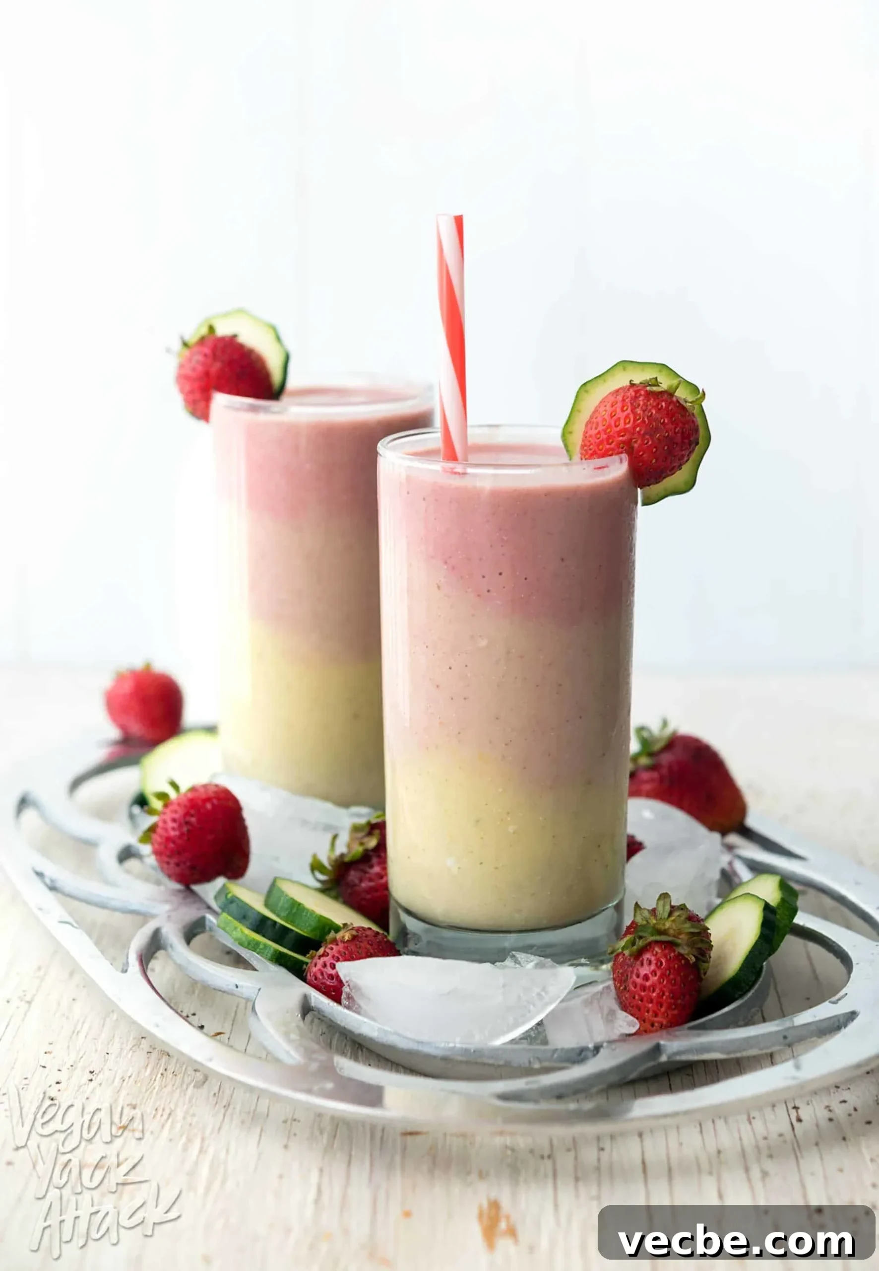 Creamy Strawberry Oat Milk Popsicles Recipe 11 Image of multi-colored smoothies, layered into two glasses, on a platter.