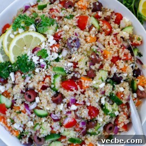 Mediterranean Quinoa Salad with Feta and Chickpeas 8 Mediterranean quinoa salad served in a dish, topped with feta cheese and lemon wedges
